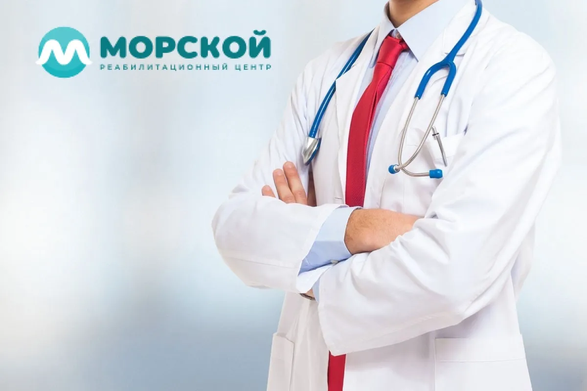 Врач в медицинском халате стоит скрестив руки Врач стоит скрестив перед собой руки