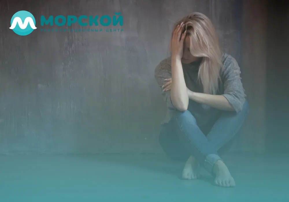 Женщина забилась в углу и плохо себя чувствует из-за птср Женщина сидит в углу комнаты на полу и плохо себя чувствует